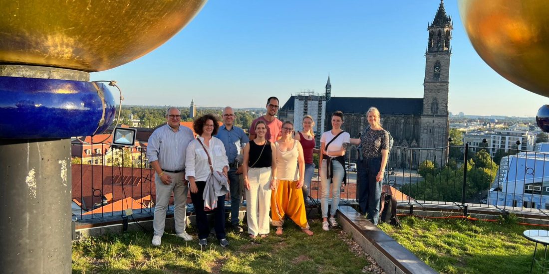 Neun Mitglieder des Senatra-Teams stehen auf der Dachterrasse der Grünen Zitadelle Magdeburg.